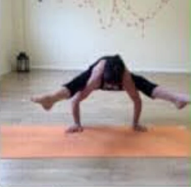 Jayne demonstrating a wide-legged arm balance